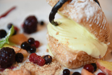 Dolce con crema e frutti di bosco servito in un ristorante