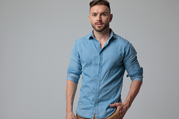 casual man standing with one hand in pocket serious