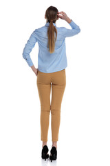 Fototapeta premium back view of young businesswoman wearing blue shirt