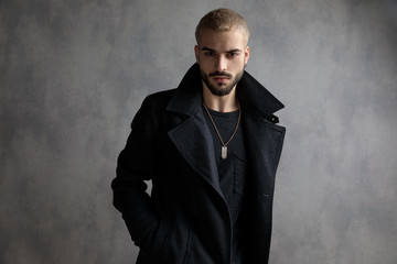 Confident young man standing with his hands in his pockets