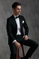 fashion elegant groom wearing tuxedo and looking to side