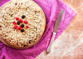 Homemade berry shortcrust pie with crumble on wooden board