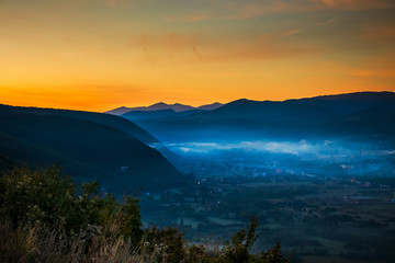 Sunrise with fog, mountains and town in the background. Drvar in Bosnia and Herzegovina.