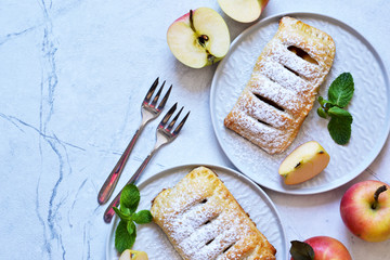 Puffs with apples and cinnamon in a plate on the kitchen table. View from above!