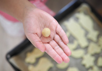 a child at home cuts out cookie cutters.