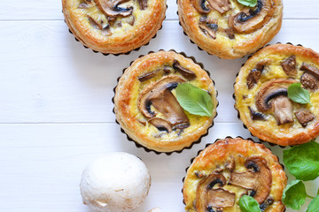 Tartlets with mushrooms and chicken on a wooden background. View from above.