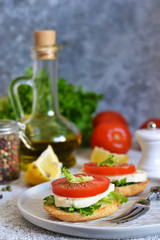 Lunch time! Sandwich with tomatoes and mozzarella on the kitchen table.