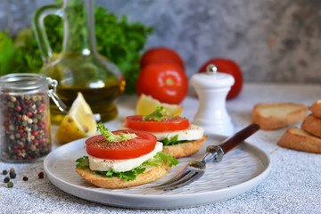 Lunch time! Sandwich with tomatoes and mozzarella on the kitchen table.