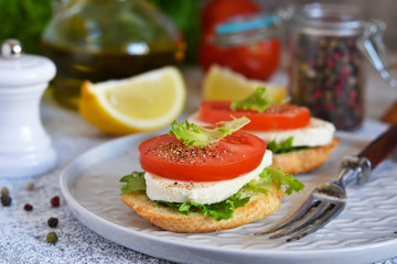 Lunch time! Sandwich with tomatoes and mozzarella on the kitchen table.