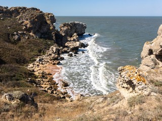 Scenic seascape of Crimea. Empty rocky beach with cliffs and broken water