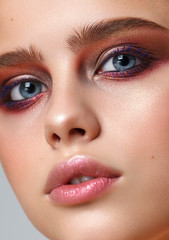 Beautiful young model with evening make up, perfect skin. Trendy colorful eye-shadows. Closeup portrait.