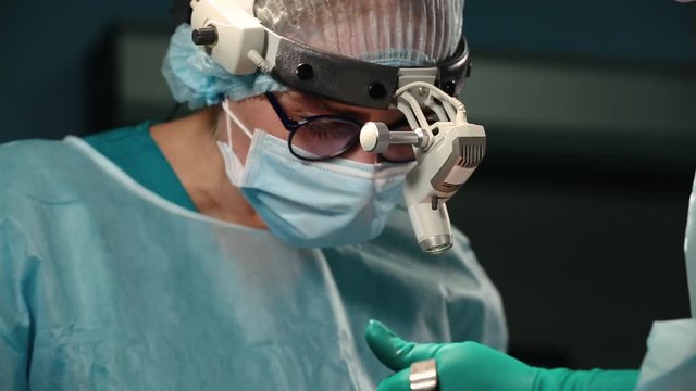 A team of surgeons has a major plan during surgery, a blue light operating room, a rhinoplasty operation to improve the aesthetics of the nose. Medetsina, plastic surgery.