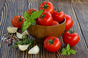 cherry tomatoes,garlic and basil on wooden board outdoors