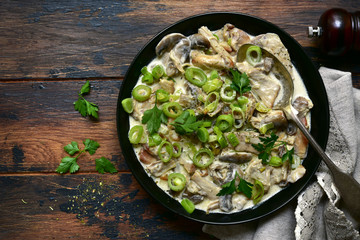 Chicken stewed with mushrooms and leek in a cream sauce. Top view with copy space.