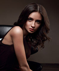 Fototapeta na wymiar Sexy young makeup model with vamp look posing on dark shadow background