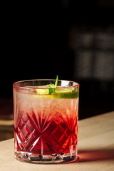 Pink and red Fresh colorful exotic alcoholic cocktail with lemon and ice in the bar. Colorful pink Soft drink with ice on the bar desk. Red colorful Mojito