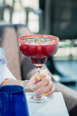 Raspberry Margarita in chilled glass over light background on reflection surface, garnished with fresh mint. Most popular cocktails series.