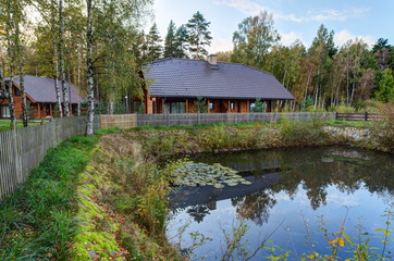 Traditional wooden house in the pine forest. Autumn in Europe.