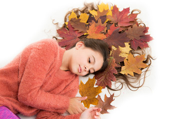 Haircare tips add to fall routine. Little girl gorgeous long hair and fallen maple leaves lay on...
