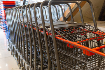 Shopping metal carts close at the grocery store. Empty carts for future purchases lie in wait for the buyer.