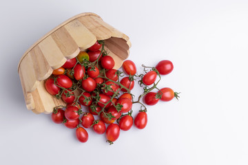 Grape or cherry tomato branch. Pile of red grape tomatoes isolated on white background, soft light