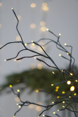 Beautiful yellow garlands in an interesting composition on the background of a Christmas tree. New Year theme for design