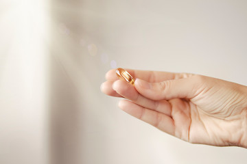 Woman in white blouse holding in hand Omega 3 fish oil supplement capsule. Bioactive additive woman pharmacy. Vitamin E skin treatment golden pill against avitaminosis. Autumn health care concept