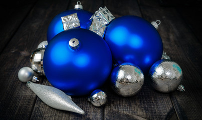 Blue Christmas balls and small presents for Christmas on a dark wooden table top. Concept of Christmas, celebration and celebrating. Upcoming free days in December. Getting closer to the holidays.