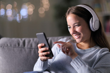Happy woman listening to music with headphones and smartphone