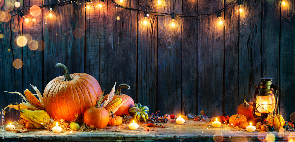 Wall mural thanksgiving - pumpkins on rustic table with candles and string lights
