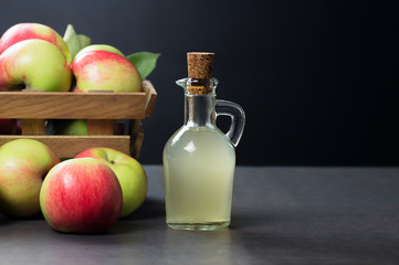 Glass bottle of handmade organic apple cider vinegar made from fermented fresh ripe apples. Healthy organic food, selective focus, space for text