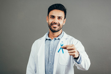 Prostate Cancer Awareness. Doctor man holding light Blue Ribbon for supporting people living and...