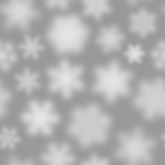 Christmas seamless pattern of white defocused snowflakes on gray background