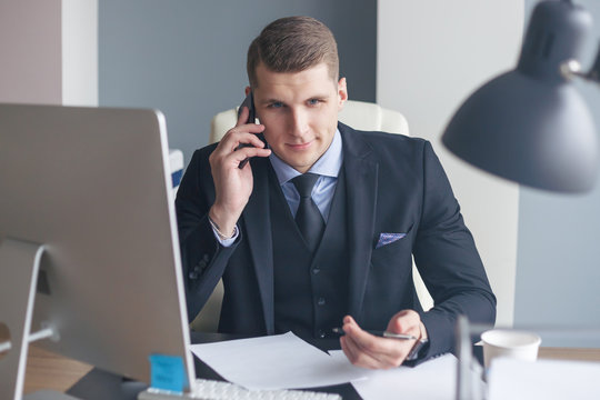 Displeased businessman sit at his desk while doing cold calls