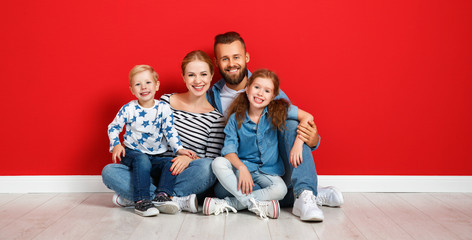 happy family mother father and children daughter and son  near an   red wall