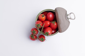 Tin of chopped canned tomatoes with whole fresh tomatoes, isolated on white background, soft light