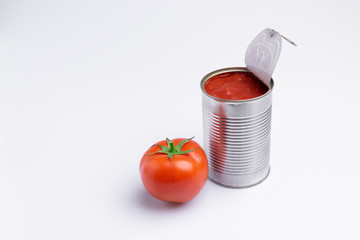 Tin of chopped canned tomatoes with whole fresh tomatoes, isolated on white background, soft light