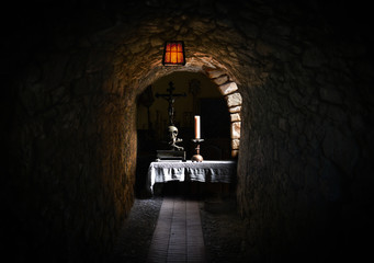 A table set with a candle and skull in a cellar