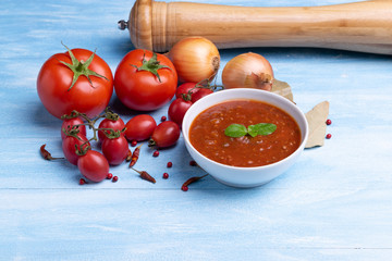 Bolognese with tomato sauce in a white plate on rustic wooden blue table background, soft light