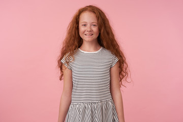 Portrait of charming lond haired redhead girl with long hair wearing casual clothes, keeping hads...