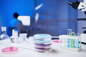 Close up of assorted glassware and test tubes and petri dishes on table in medical laboratory, copy space