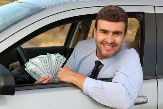 Elegant driver holding lots of dollars