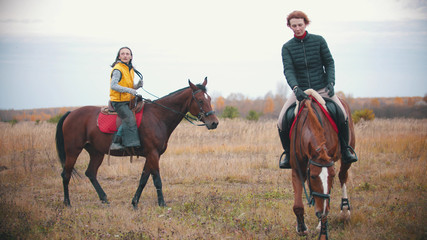 Two women on the horses backs are walking