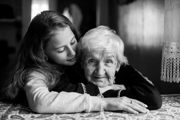 Elderly grandmother with her little girl granddaughter. Portrait black-and-white.
