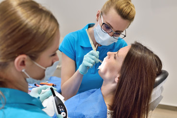 Dentist And Assistant Examine Patient