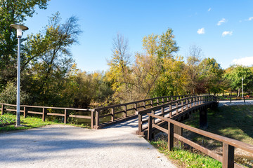 Fototapeta premium A light post and a wooden bridge in Bundek city park, Zagreb, Croatia