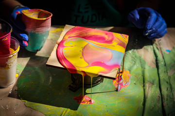 Pouring thick acrylic paint on ceramic tiles. Art training