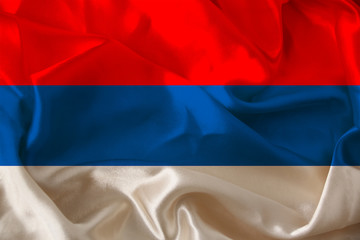 beautiful photo of the colored national flag of the modern state of Serbia on a textured fabric, concept of tourism, emigration, economy and politics, close up
