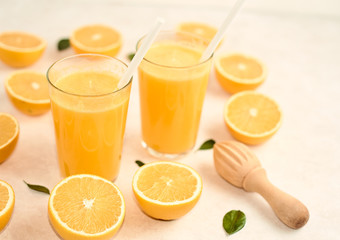 freshly squeezed orange juice in glasses on the kitchen table with slices of oranges, concept of diet and healthy lifestyle