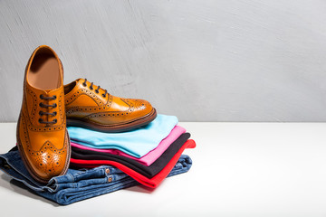 Pair of Male Full Brogued Tan Oxford Shoes Placed on Top of Heap Of Clothing.